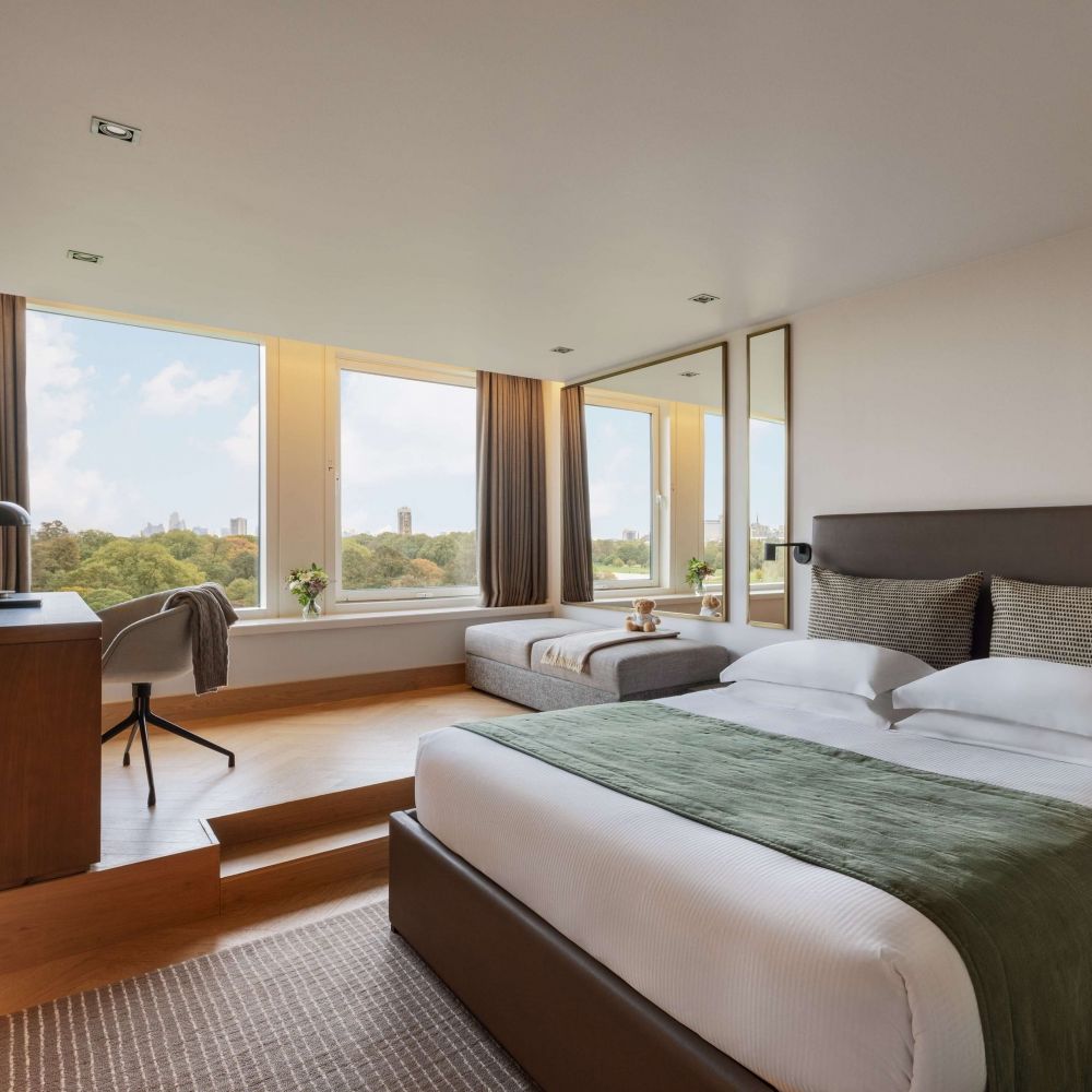 Refurbished and comfortable guest room at Royal Garden Hotel overlooking the verdant view of Kensington Gardens.